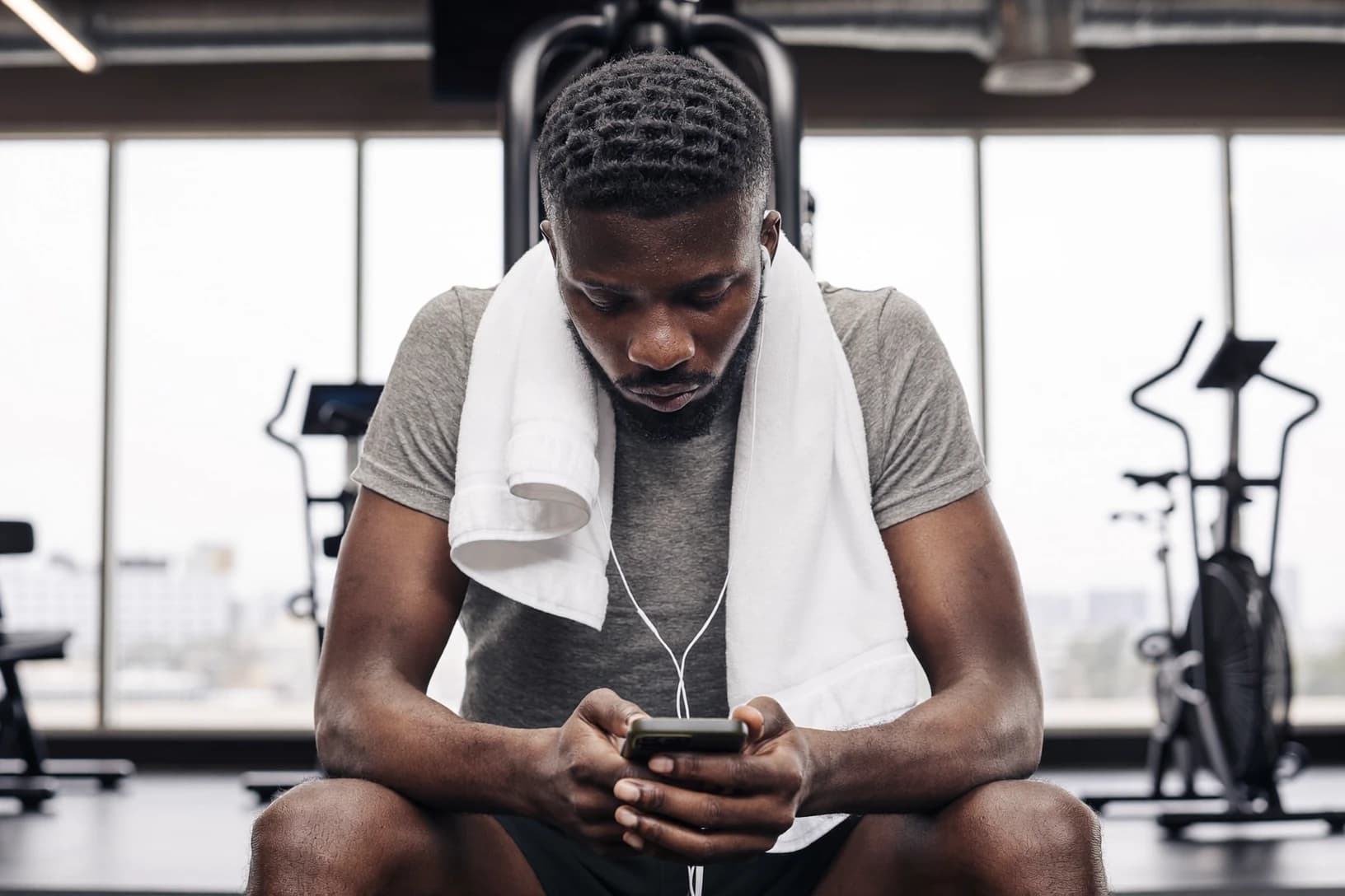 Athlete checking the StayFit app on their phone between sets
